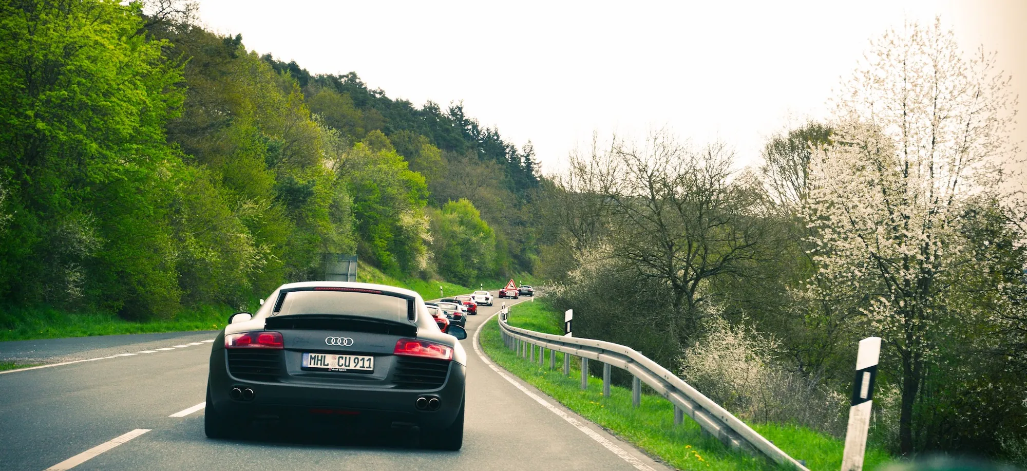 Fahrzeugkonvoi auf einer kurvigen Landstraße in der Eifel